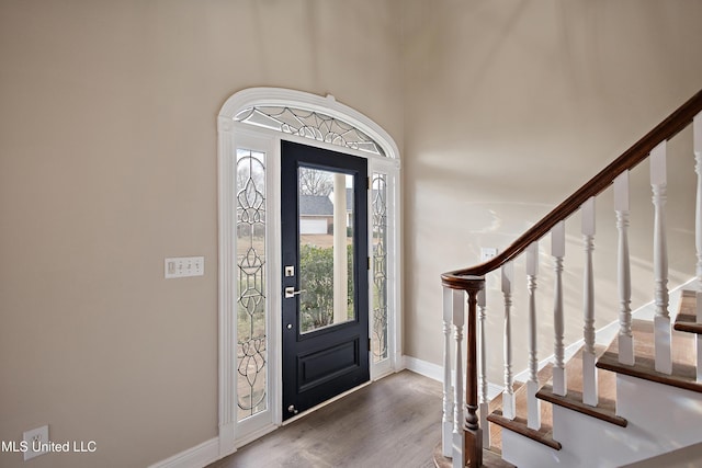 entrance foyer with stairs, baseboards, and wood finished floors