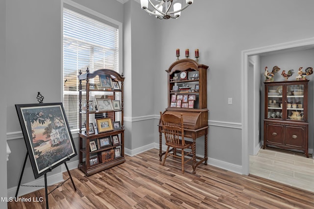 sitting room with light wood-style floors, baseboards, and a chandelier