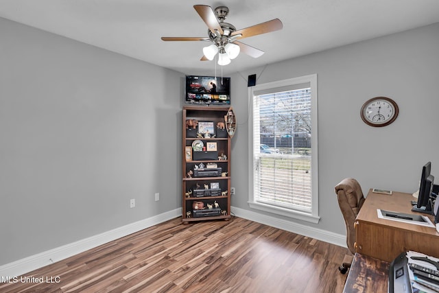 office space featuring a ceiling fan, baseboards, and wood finished floors