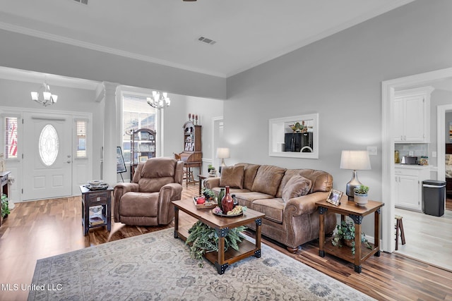 living area featuring a chandelier, visible vents, and light wood finished floors