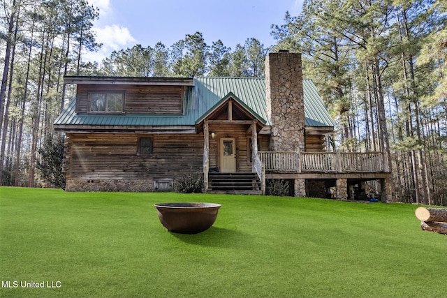 log-style house with a wooden deck and a front lawn