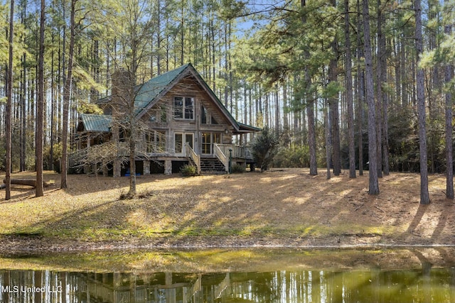 back of property with a deck with water view