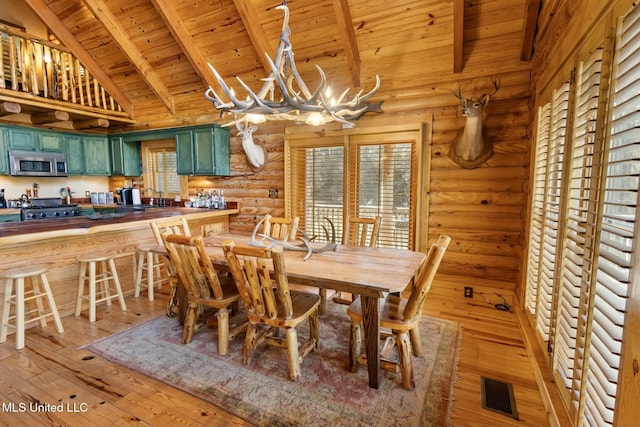 dining area with hardwood / wood-style flooring, wood ceiling, a wealth of natural light, and a notable chandelier