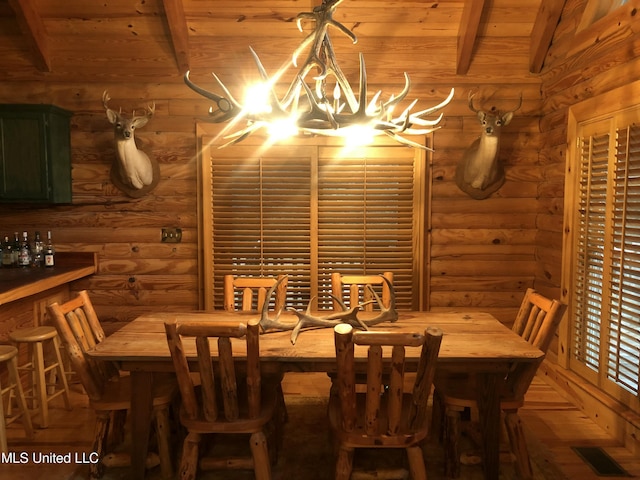 dining area featuring wood ceiling, log walls, and beamed ceiling