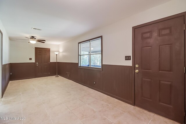 6533 Shawnee St, Kiln, MS 39556 - entryway featuring ceiling fan, visible vents, wainscoting, light tile patterned floors, and wooden walls
