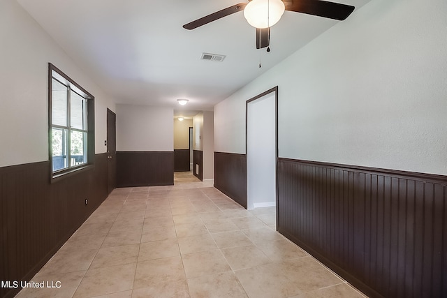 hall with wood walls and light tile patterned flooring