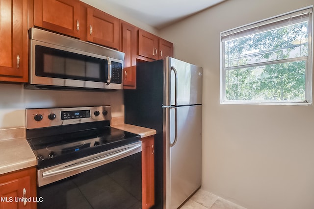 kitchen with appliances with stainless steel finishes and light tile patterned floors