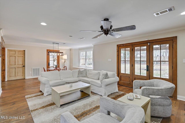 living room featuring hardwood / wood-style floors, ornamental molding, and french doors