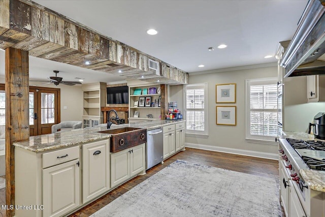 kitchen featuring premium range hood, dark wood-type flooring, sink, light stone counters, and stainless steel dishwasher