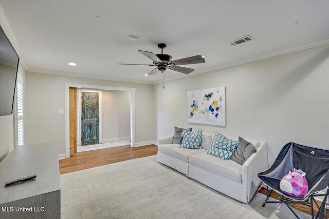 living room featuring crown molding, ceiling fan, and wood-type flooring