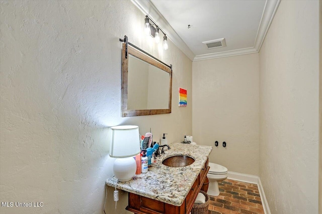 bathroom featuring vanity, crown molding, and toilet