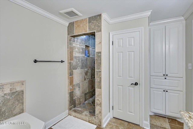 bathroom with ornamental molding and tiled shower