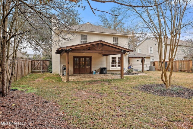 rear view of house with a patio, a lawn, and french doors