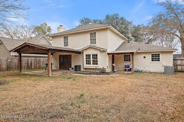 back of house featuring cooling unit and a lawn