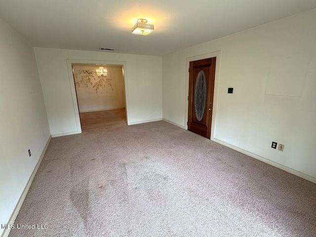 empty room with carpet floors, visible vents, and baseboards