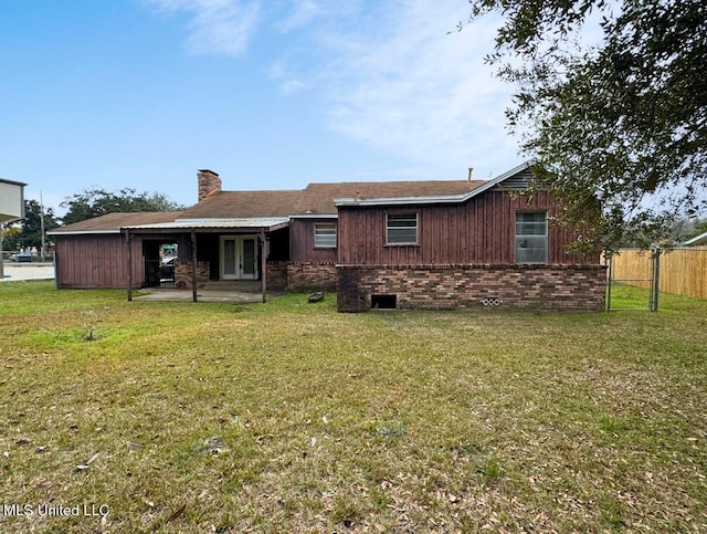 back of property with a yard, french doors, a patio area, and brick siding