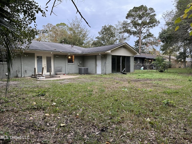 back of house featuring central AC unit and a yard