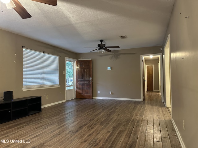 interior space with ceiling fan, dark hardwood / wood-style flooring, and a textured ceiling