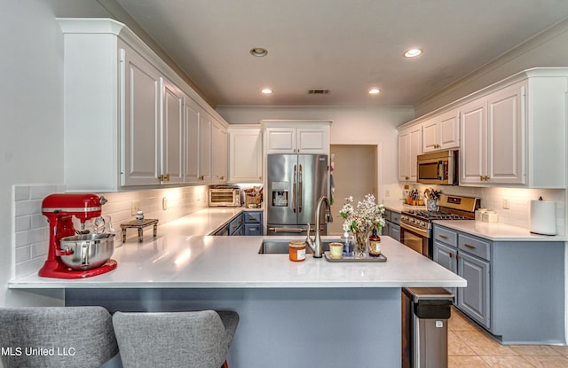 865 Wellington Way, Madison, MS 39110 - kitchen with appliances with stainless steel finishes, a sink, a peninsula, tasteful backsplash, and gray cabinetry