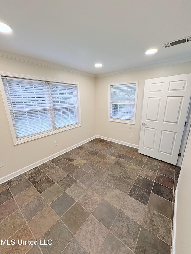 spare room with visible vents, crown molding, and plenty of natural light