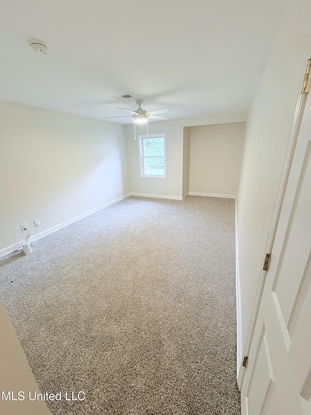 unfurnished room featuring baseboards, a ceiling fan, carpet floors, and visible vents