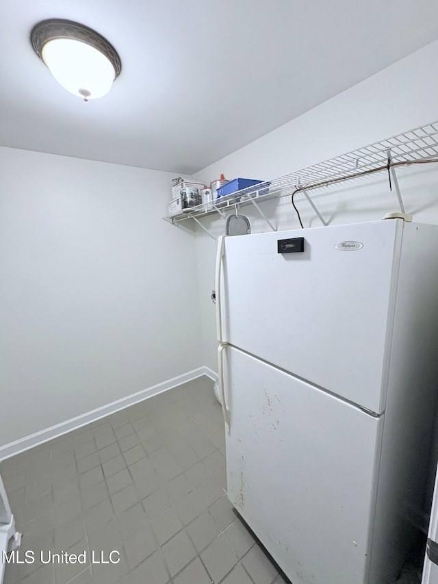 laundry area featuring laundry area, baseboards, and tile patterned floors