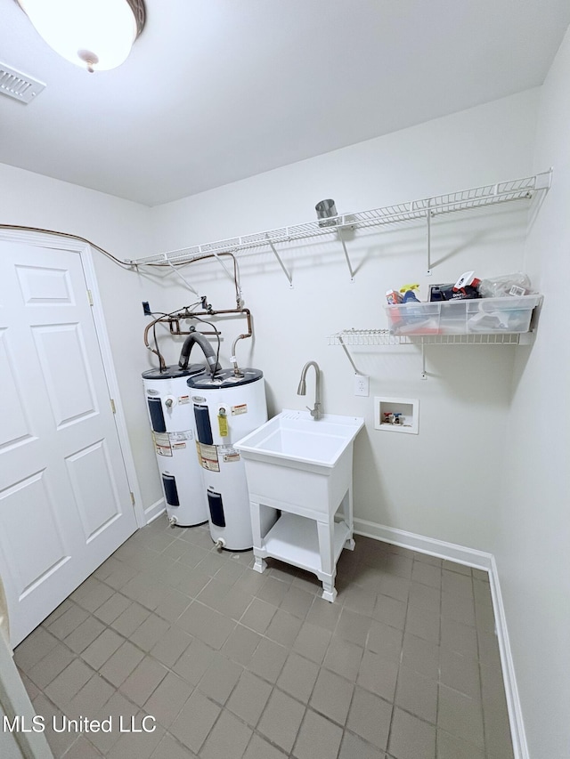 laundry area featuring water heater, washer hookup, laundry area, and tile patterned floors
