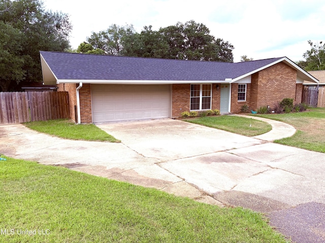 single story home with fence, an attached garage, brick siding, a front yard, and concrete driveway
