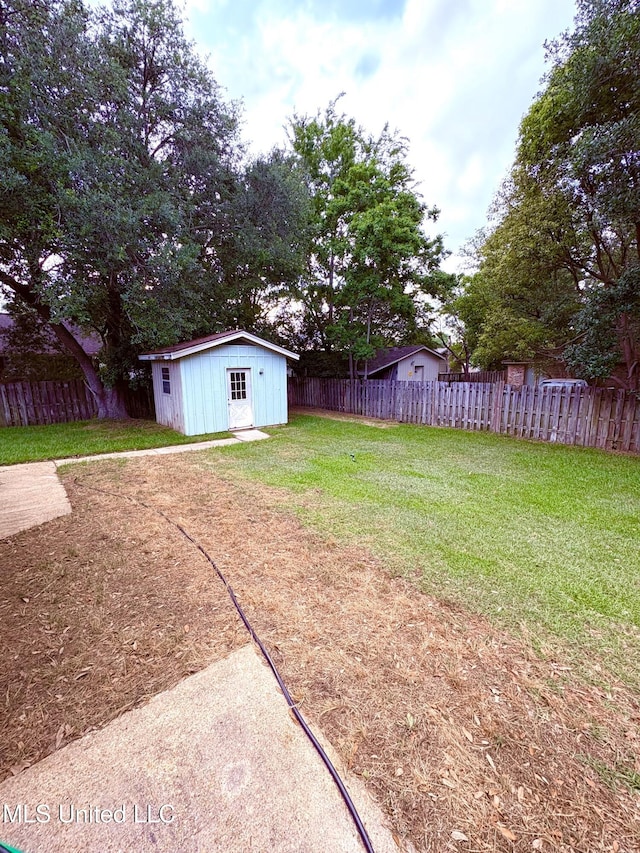 view of yard featuring a storage shed, an outdoor structure, and a fenced backyard