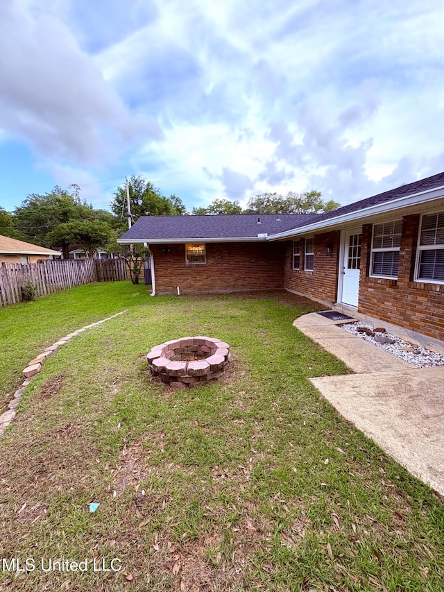 view of yard with a fire pit and fence