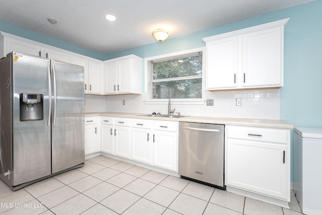 kitchen featuring white cabinetry, stainless steel appliances, sink, and light tile patterned flooring