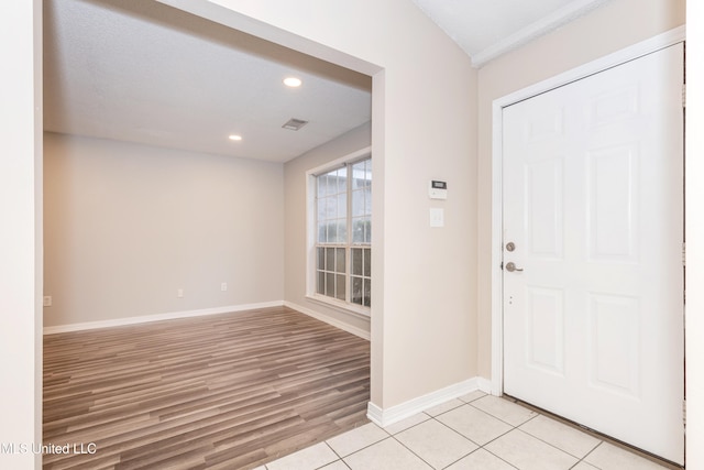 foyer entrance featuring a textured ceiling and light wood-type flooring