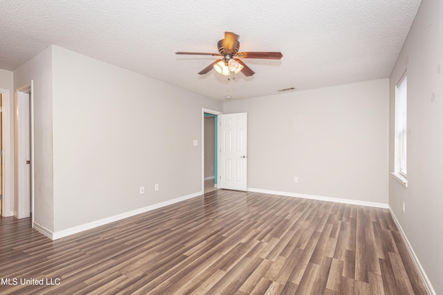 empty room with ceiling fan, a textured ceiling, and dark hardwood / wood-style floors