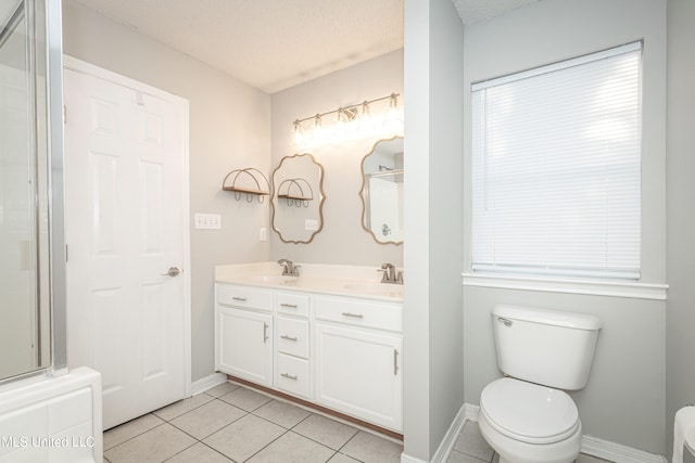 bathroom with toilet, a textured ceiling, vanity, and tile patterned flooring