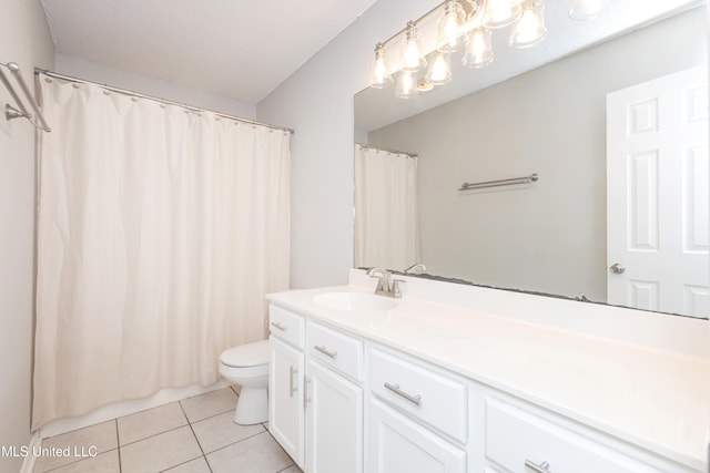 bathroom with a textured ceiling, toilet, vanity, curtained shower, and tile patterned flooring