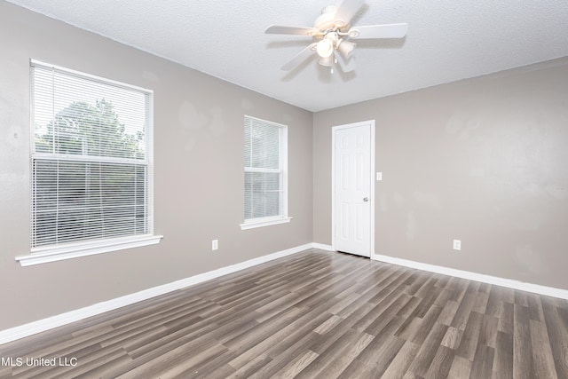 spare room with ceiling fan, a textured ceiling, and dark hardwood / wood-style floors