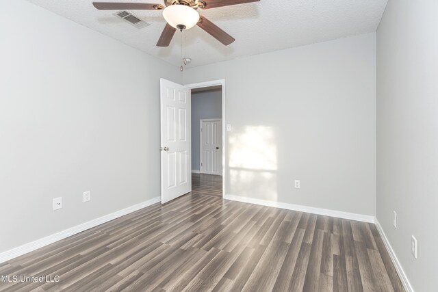 empty room with a textured ceiling, dark hardwood / wood-style floors, and ceiling fan