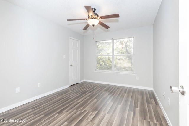 empty room featuring dark wood-type flooring, a textured ceiling, and ceiling fan