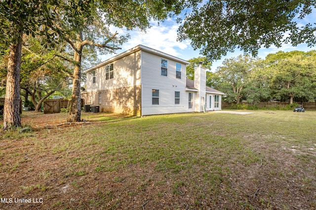 back of house with a yard and cooling unit