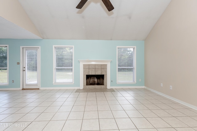 unfurnished living room featuring light tile patterned floors, lofted ceiling, a tile fireplace, and ceiling fan