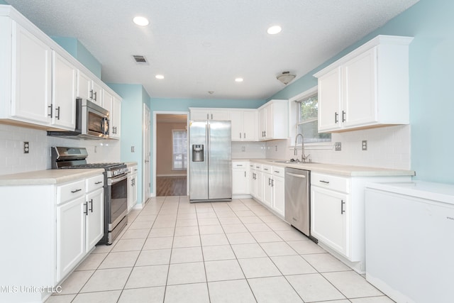 kitchen with stainless steel appliances, sink, and white cabinets