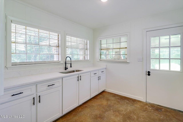 437 Henry Byrd Rd, Florence, MS 39073 - kitchen with unfinished concrete floors, healthy amount of natural light, white cabinetry, and light countertops