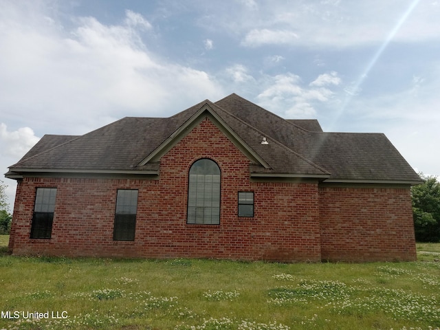 38 3rd St, Cleveland, MS 38732 - view of side of property featuring roof with shingles, a lawn, and brick siding