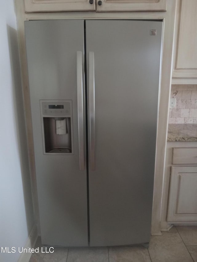 38 3rd St, Cleveland, MS 38732 - room details with cream cabinets, light stone counters, stainless steel fridge with ice dispenser, and tasteful backsplash