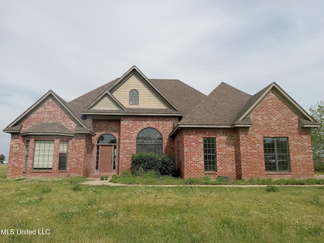 38 3rd St, Cleveland, MS 38732 - view of front of home with brick siding, a front yard, and roof with shingles