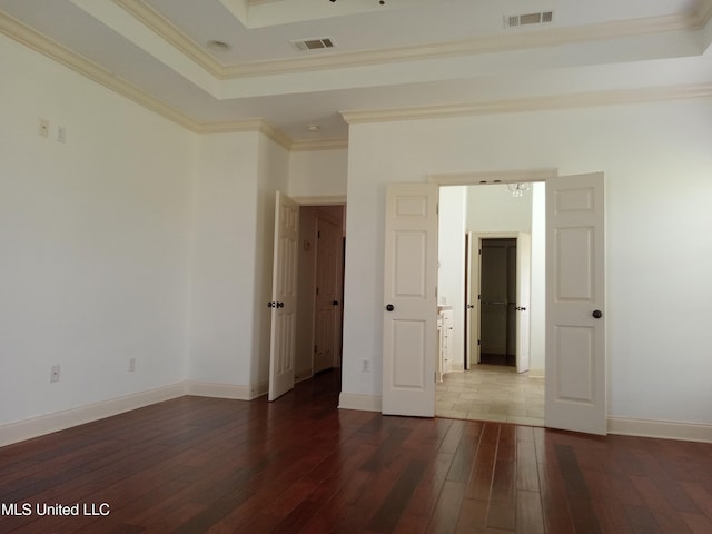 38 3rd St, Cleveland, MS 38732 - spare room with crown molding, visible vents, a raised ceiling, and dark wood-type flooring
