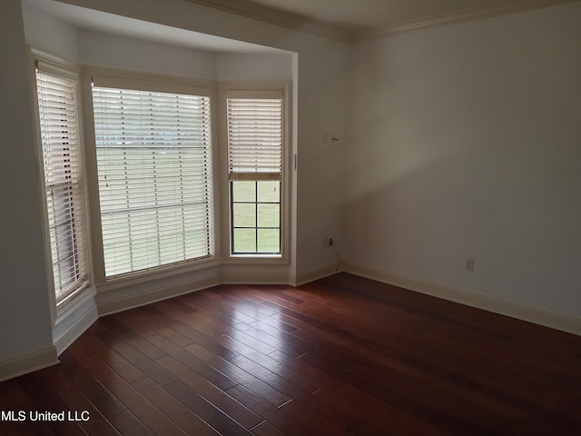 38 3rd St, Cleveland, MS 38732 - spare room with baseboards, dark wood-type flooring, and crown molding
