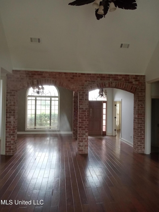 38 3rd St, Cleveland, MS 38732 - unfurnished living room featuring dark wood-style flooring, brick wall, decorative columns, and visible vents