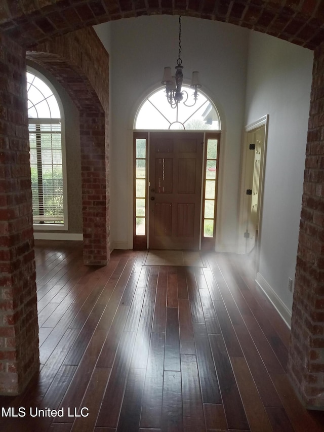 38 3rd St, Cleveland, MS 38732 - entrance foyer with a towering ceiling, arched walkways, baseboards, dark wood-style floors, and a chandelier