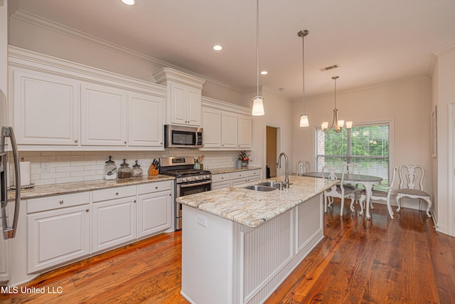 228 Falls Xing, Madison, MS 39110 - kitchen featuring appliances with stainless steel finishes, a sink, white cabinetry, backsplash, and a chandelier